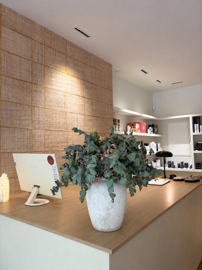 Mostrador de madera, vegetación y revestimiento de rafia en Aqua Aura