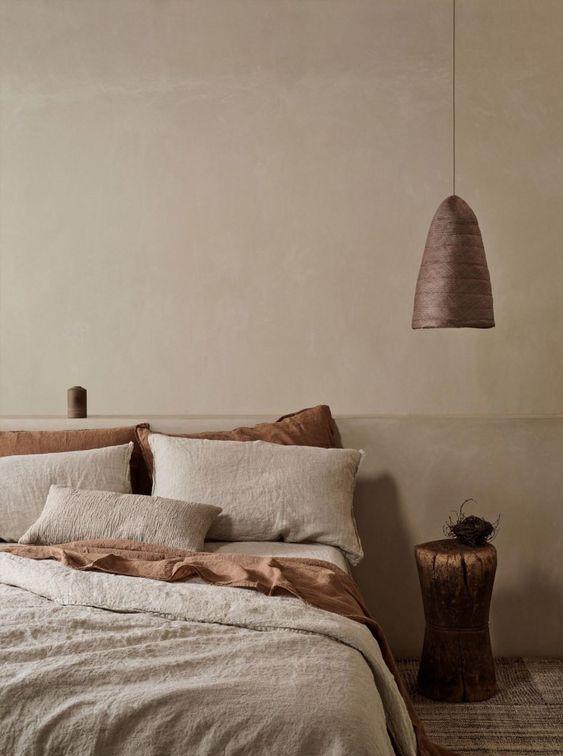 Dormitorio con lámpara colgante de pantalla opaca junto a la cama