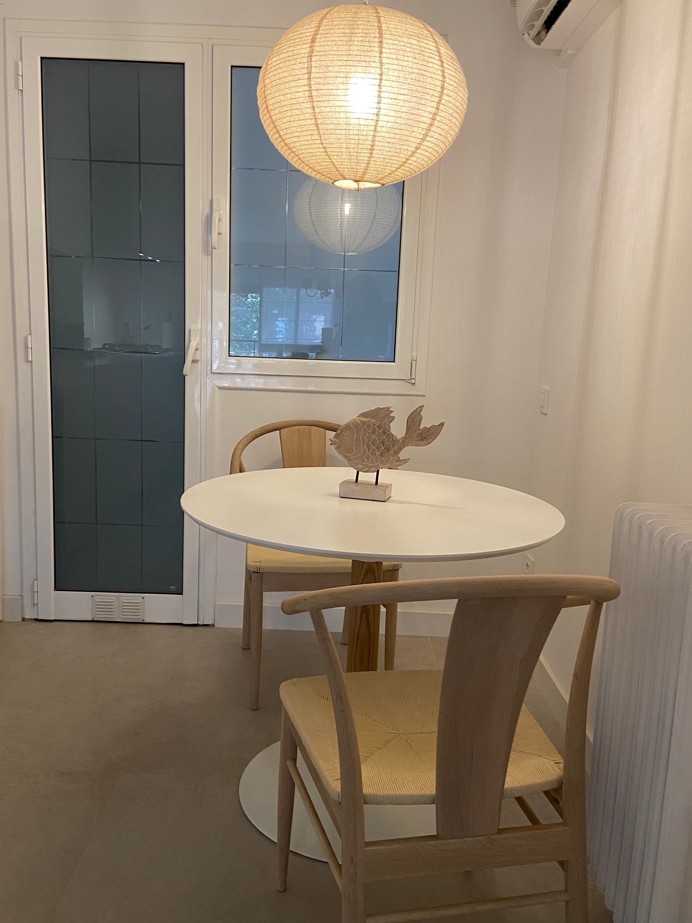 Cocina abierta con mesa redonda, tonos neutros y luz natural en Barcelona
