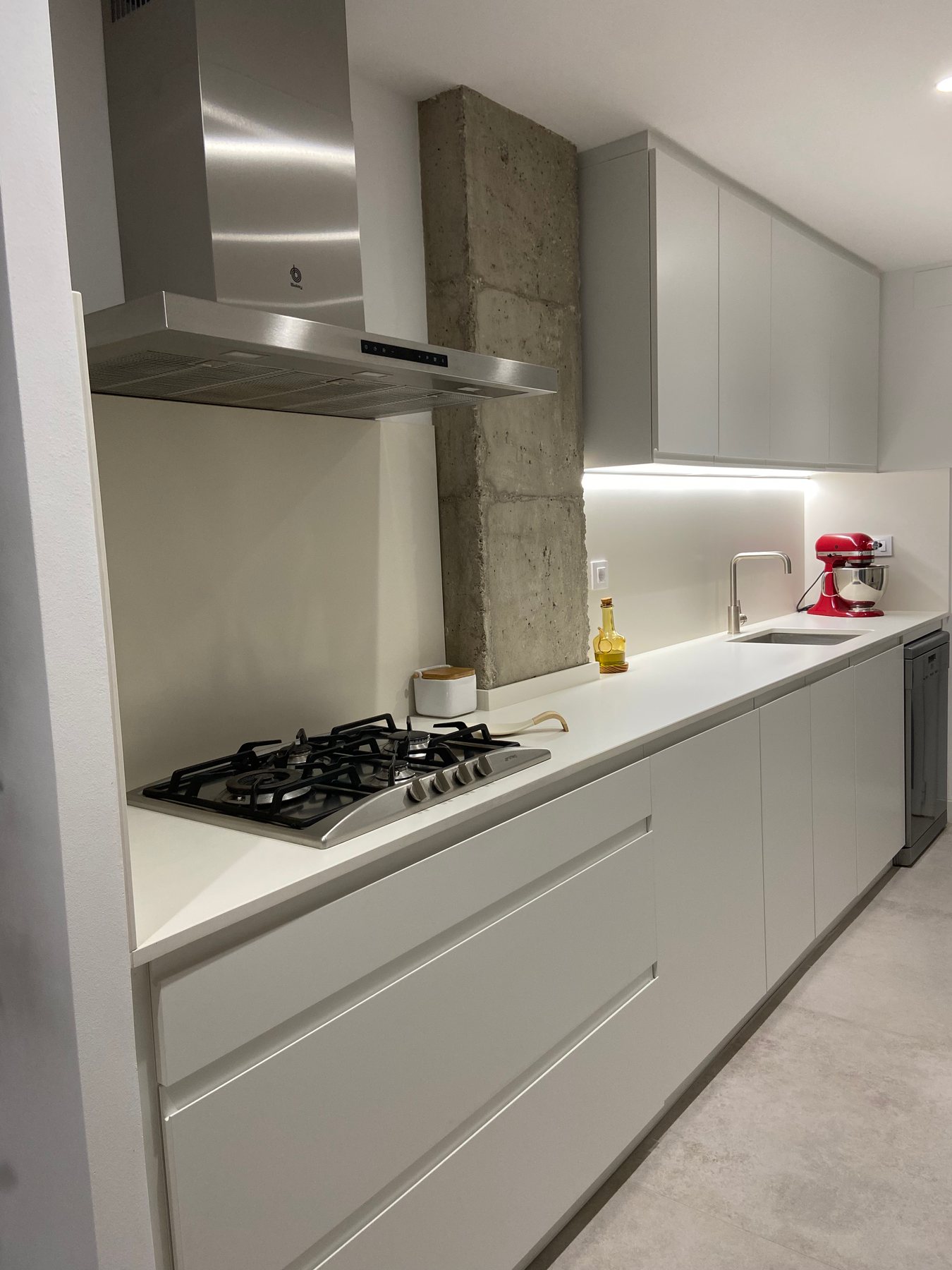 Comedor y cocina abierta con materiales serenos e iluminación cálida