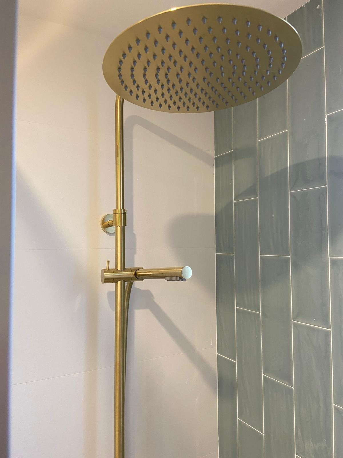 Ducha reformada en Molins de Rei con grifería de latón y azulejo verde artesanal