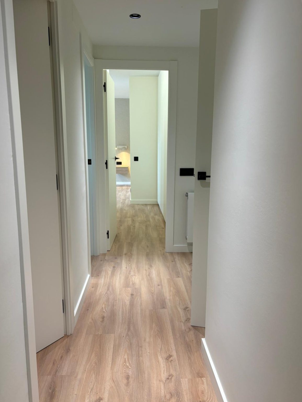 Distribución interior luminosa de vivienda reformada con acabados neutros
